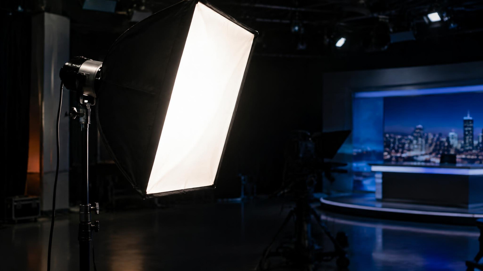 Studio softbox light glowing on a stand in a dark studio