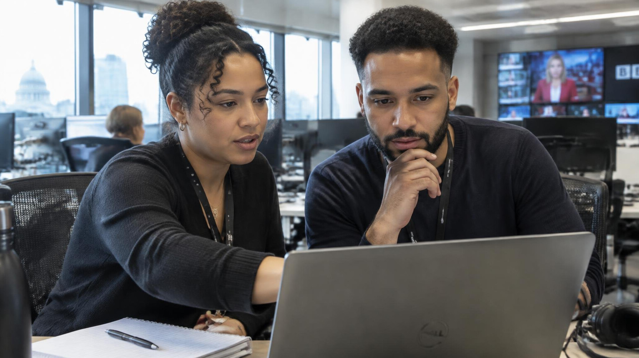 Newsroom producers reviewing a workflow schedule together